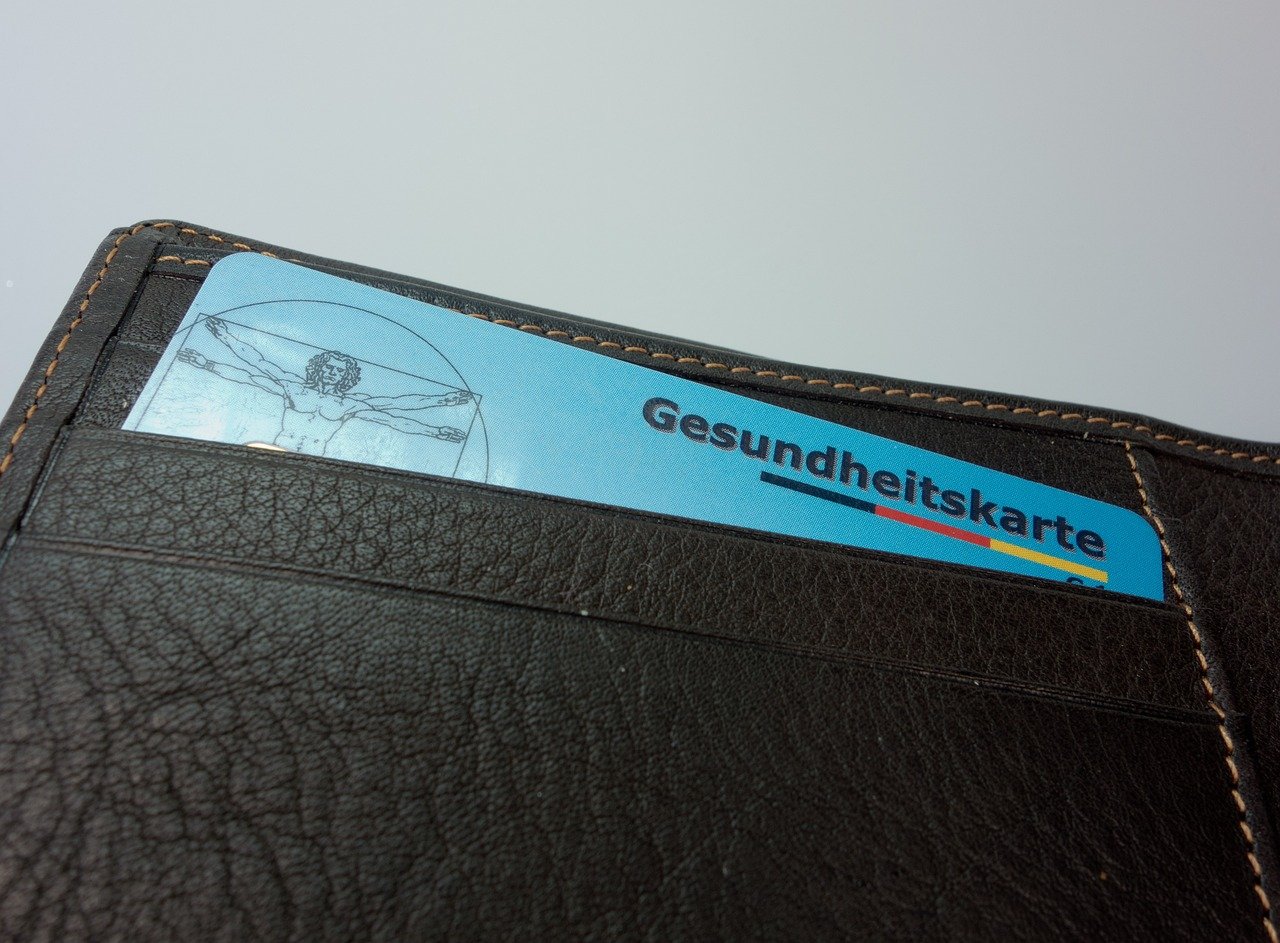 Health card and money in a wallet, representing Super Budget Insurance for health