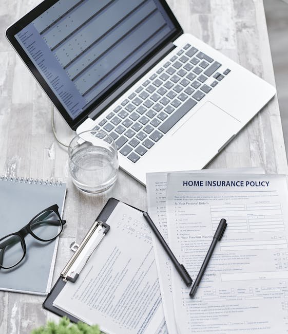 Desktop setup with laptop and Bankrate - Home Insurance documents, showing digital comparison.