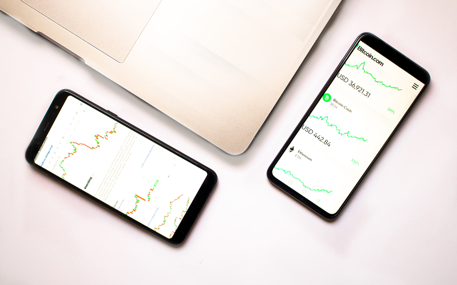 money.com - Two smartphones with cryptocurrency data and graphs, ideal for financial insights.